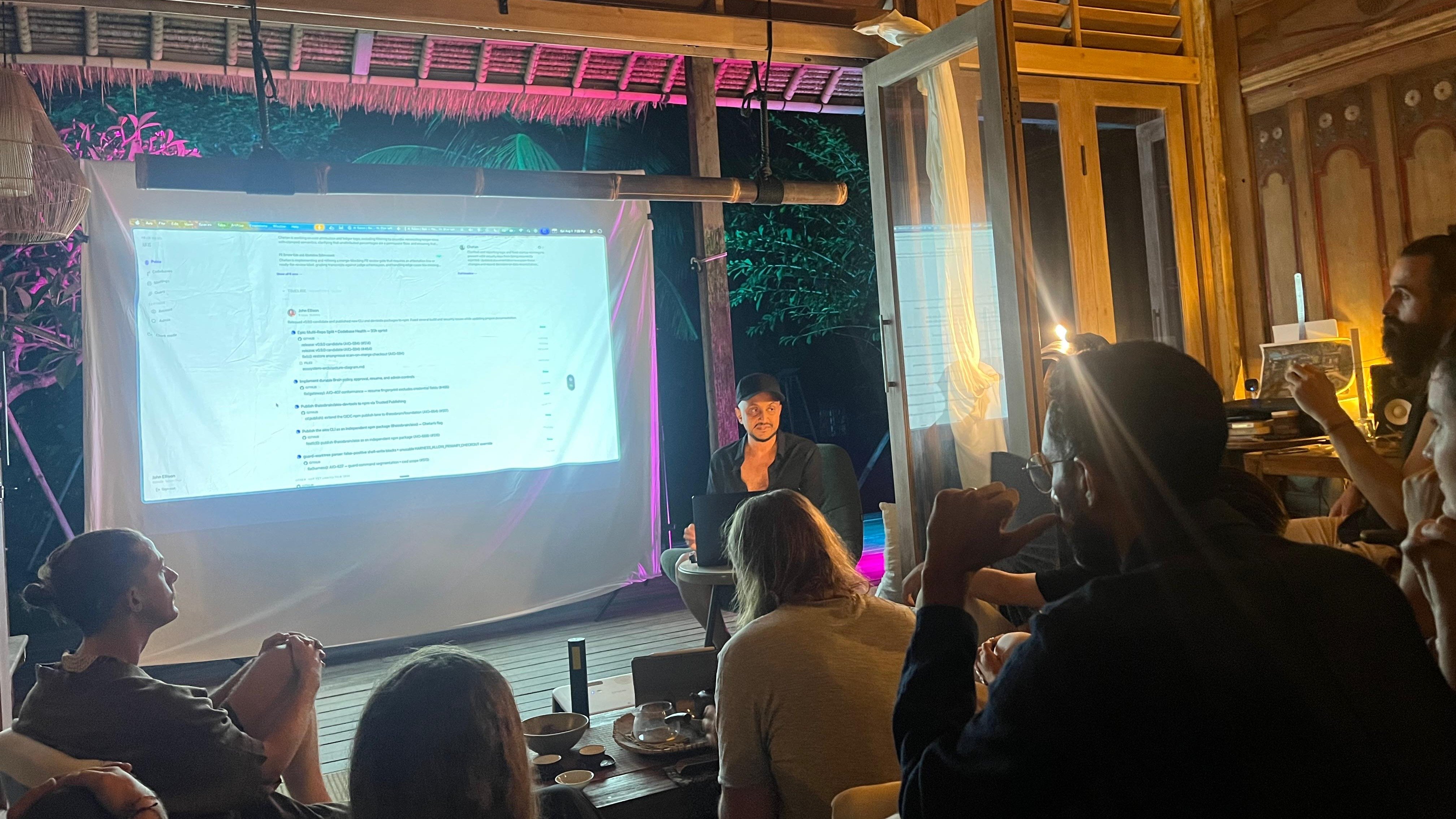 Chetan Nandakumar presenting AIOS to a room at an AI Salon evening in Bali.
